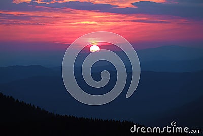 Fantastic sunset enlightens the sky with marvelous colors : bright pink, yellow, orange. The landscape of the mountains. Stock Photo