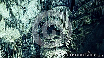 fantastic texture of round curves of stalactites in the cave, green light Stock Photo