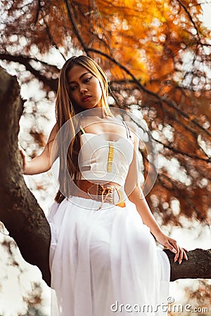 Fantastic young woman. beautiful fantasy girl fairy with white long dress in windy autumn park Stock Photo