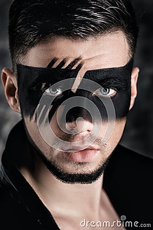 Fantasy art makeup. man with black painted mask on face. Close up Portrait. Professional Fashion Makeup. Stock Photo