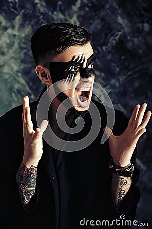 Fantasy art makeup. man with black painted mask on face. Close up Portrait. Professional Fashion Makeup. Stock Photo