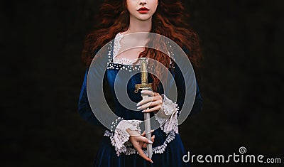 Fantasy woman warrior on black background, lady with red lips, long hair hands close up holding dagger, knife short Stock Photo