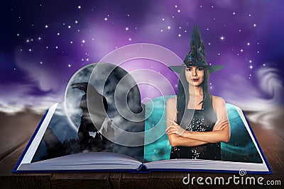 Fantasy world. Open book of fairytales with witch and black crow on pages Stock Photo