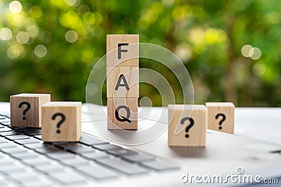 FAQ - Frequently ask question on a wood blocks with question marks Stock Photo