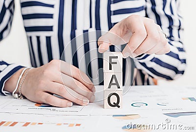 FAQ word on wooden block pyramid in business woman hand. FAQ question concept Stock Photo