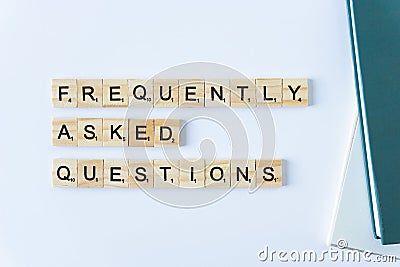 FAQS or Frequently asked questions word made with building blocks isolated on white. Wooden blocks with the word FAQ Editorial Stock Photo