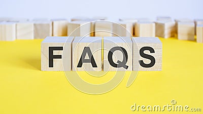faqs word on wooden building blocks lying on the yellow table, concept Stock Photo