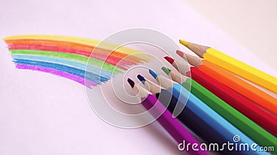 Farbige Bleistifte liegen an der Zeichnung eines Regenbogens auf einer Tabelle Helle bunte Zeichnung Regenbogen stock video footage Farbige Bleistifte liegen an der Zeichnung eines Regenbogens auf einer Tabelle Helle bunte Zeichnung Regenbogen stock video footage