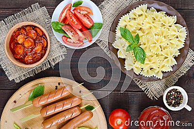 Farfalle pasta, sausages on skewers, fresh tomatoes, spicy tomato sauce Stock Photo