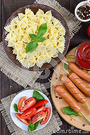 Farfalle pasta, sausages on skewers, fresh tomatoes, spicy tomato sauce. Stock Photo
