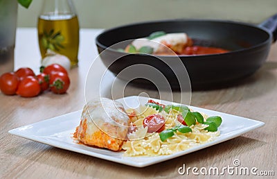 Farfalle pasta in tomato sauce with chicken, basil in plate Stock Photo