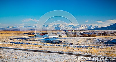 Farm buildings dot the scenic landscapes of Iceland in Winter Stock Photo