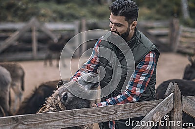 Farmer and his flock on a cattle-farm Stock Photo