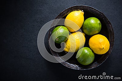 Farm fresh lemon and lime fruit in rustic bowl Stock Photo