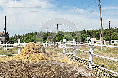 Farm scene with wooden log fence, bale of hay and barn. Countryside rural landscape Stock Photo