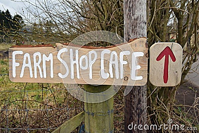 Farm shop and cafe sign with red arrow and rural background Editorial Stock Photo