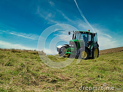 A farm tractor carrying out silaging operations on the Llyn Peninsula, Gwynedd, Wales, UK Editorial Stock Photo