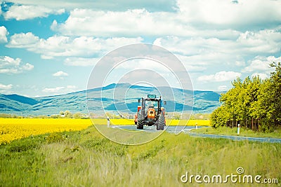 Farm tractor drives on road Stock Photo