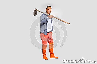 A farmer carrying a hoe on his shoulder Isolated from the white background. Stock Photo