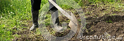 Farmer digging the soil with the shovel, young adult man working in the agricultural field Stock Photo