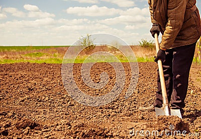 Farmer digging spring farmland soil Stock Photo