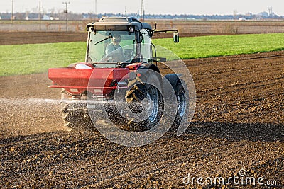Farmer fertilizing arable land with nitrogen, phosphorus, potassium fertilizer Stock Photo