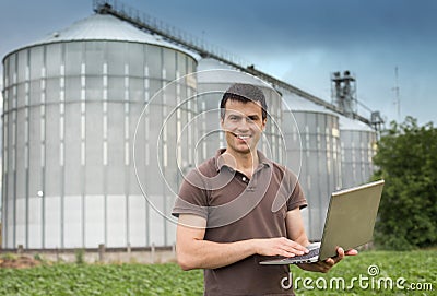 Farmer in front of grain silo Stock Photo