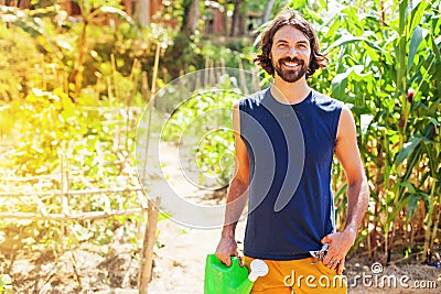 Farmer holding a watering can in a garden Stock Photo