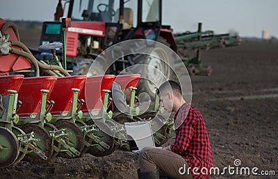 Farmer with laptop and tractors Stock Photo