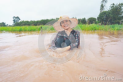 Farmer playing and joyful in heavy flood in rice field Stock Photo