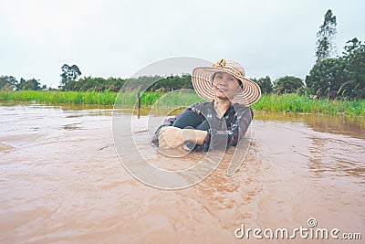 Farmer playing and joyful in heavy flood in rice field Stock Photo