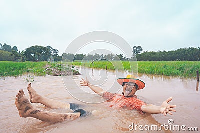 Farmer playing and joyful in heavy flood in rice field Stock Photo