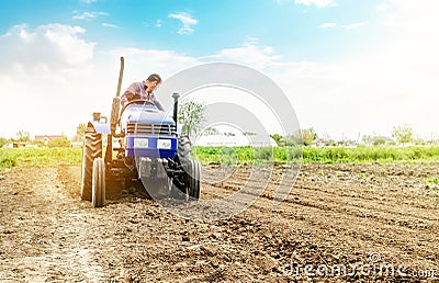 Farmer is processing soil on a tractor. Soil milling, crumbling mixing. Loosening surface, cultivating land for further planting. Stock Photo