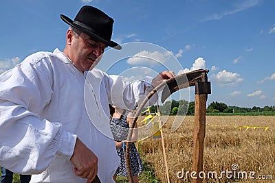 Farmer sharpening the scythe Editorial Stock Photo