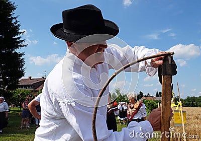 Farmer sharpening the scythe Editorial Stock Photo