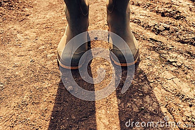 Farmer standing on dirt country road, close up of boots Stock Photo