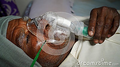 Farmer taking Emergency Oxygen with Cannula. Severe causes due to Covid in India concept Stock Photo