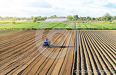 Farmer on a tractor cultivates land after harvesting. Development of agricultural technologies. Cultivating soil for further Stock Photo