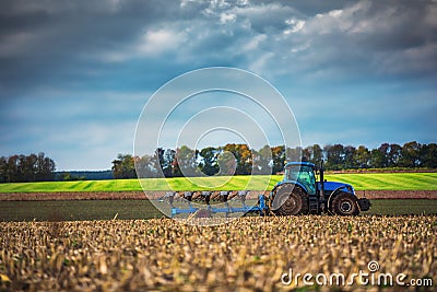 Farmer in tractor preparing land with seedbed cultivator Stock Photo