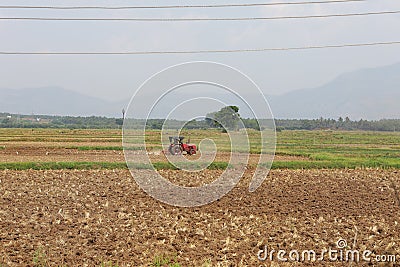 Farmer with tractor and trailer ploughing the field Stock Photo