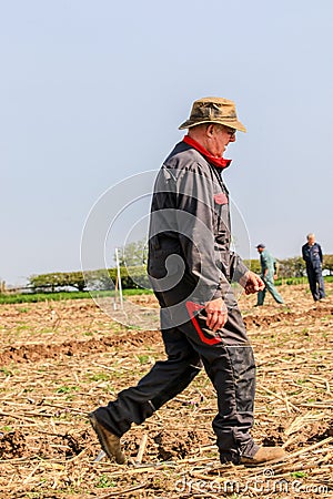 Farmer walking in ploughed field Editorial Stock Photo