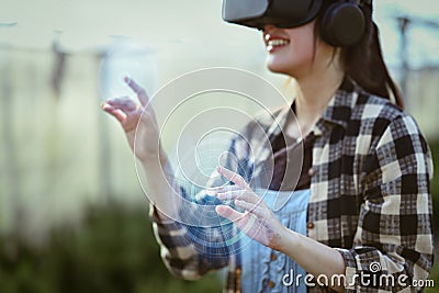 Farmer wearing VR headset for controlling process in greenhouse cultivation. Modern and smart agriculture concept. Stock Photo