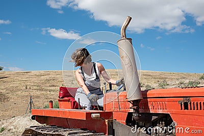 Farmer woman maneuvering a tractor on her farm Stock Photo