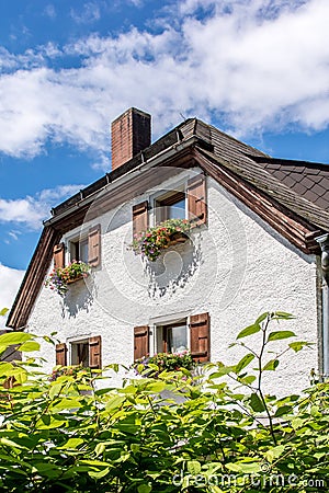 Part of an old farmhouse with flower boxes on the windows Stock Photo