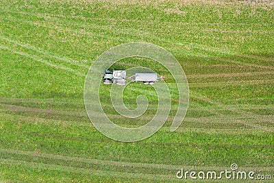 Farming machine spraying cow dung on a field from above Stock Photo