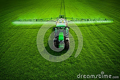 Aerial view of farming tractor plowing and spraying on field Stock Photo