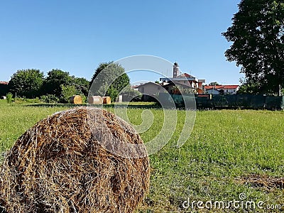Farmlands in italy with haybales and church Stock Photo