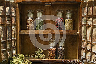 Vintage Wooden Spice Rack or Storage Cabinet and six glass bottles Stock Photo