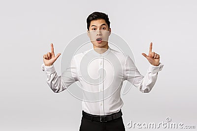 Fascinated, impressed and surprised attractive asian guy with short stylish haircut, wear formal outfit, open mouth in Stock Photo