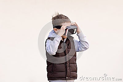 Fascinated little boy watching movie in VR virtual reality goggles Stock Photo